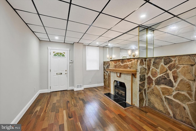 406 S Eaton St, Baltimore, MD 21224 - unfurnished living room featuring baseboards, wood finished floors, a tile fireplace, and a paneled ceiling