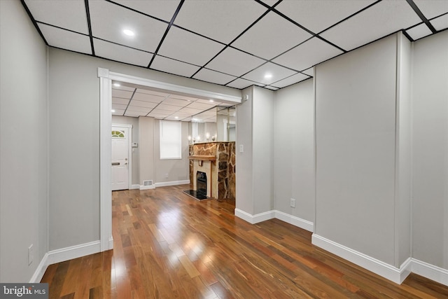 406 S Eaton St, Baltimore, MD 21224 - unfurnished living room featuring hardwood / wood-style flooring, a fireplace, baseboards, a drop ceiling, and recessed lighting