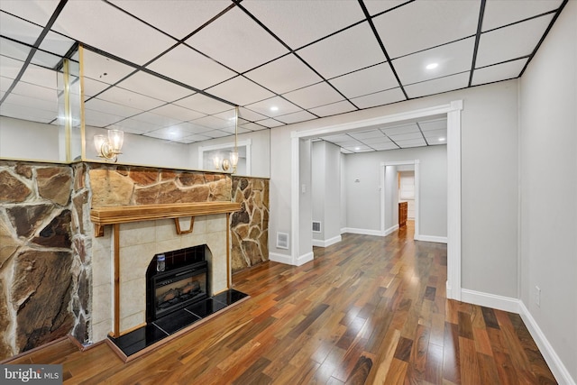 406 S Eaton St, Baltimore, MD 21224 - unfurnished living room with wood finished floors, a fireplace with raised hearth, baseboards, a paneled ceiling, and recessed lighting