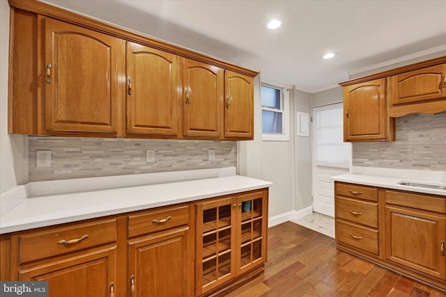 406 S Eaton St, Baltimore, MD 21224 - kitchen with tasteful backsplash, brown cabinetry, light countertops, dark wood-type flooring, and recessed lighting