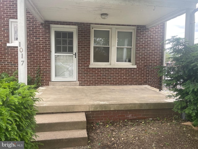 entrance to property featuring brick siding