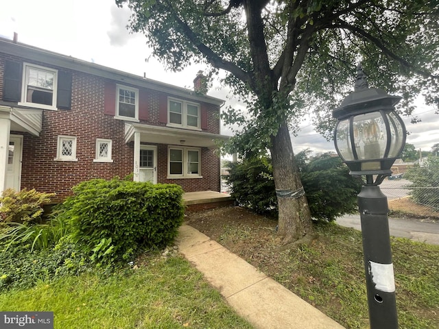 view of front of house featuring brick siding and a chimney