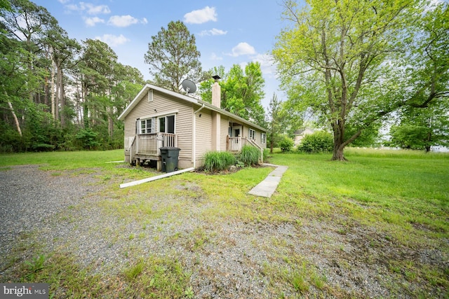 1211 Mcglaughlin Rd, Fishing Creek, MD 21634 - view of side of property with a chimney, a lawn, and a deck