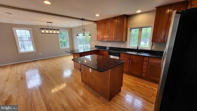 kitchen featuring a sink, freestanding refrigerator, light wood-style flooring, a peninsula, and recessed lighting