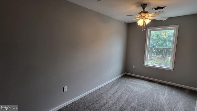 carpeted spare room featuring a ceiling fan and baseboards