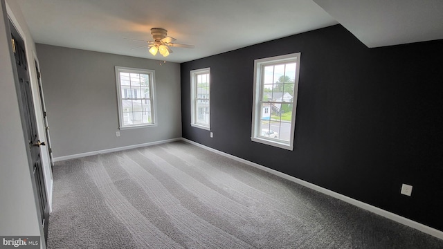 spare room with plenty of natural light, baseboards, ceiling fan, and light carpet