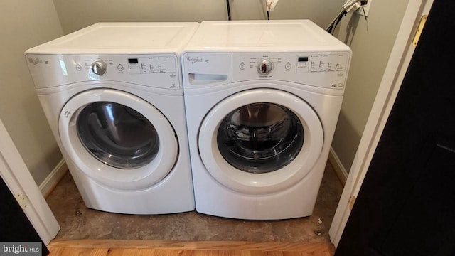 washroom with washer and clothes dryer and baseboards
