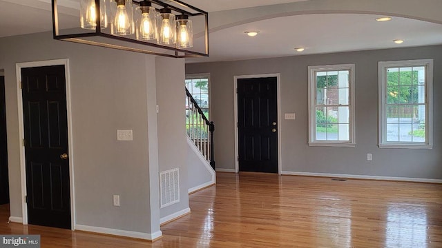 foyer entrance featuring plenty of natural light, arched walkways, light wood finished floors, baseboards, and recessed lighting