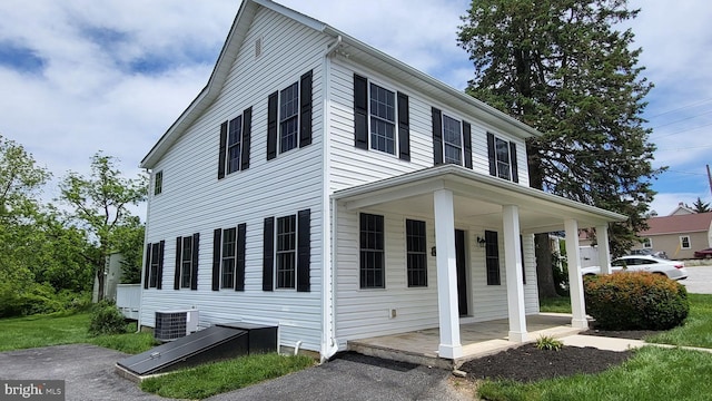 view of home's exterior with cooling unit and covered porch