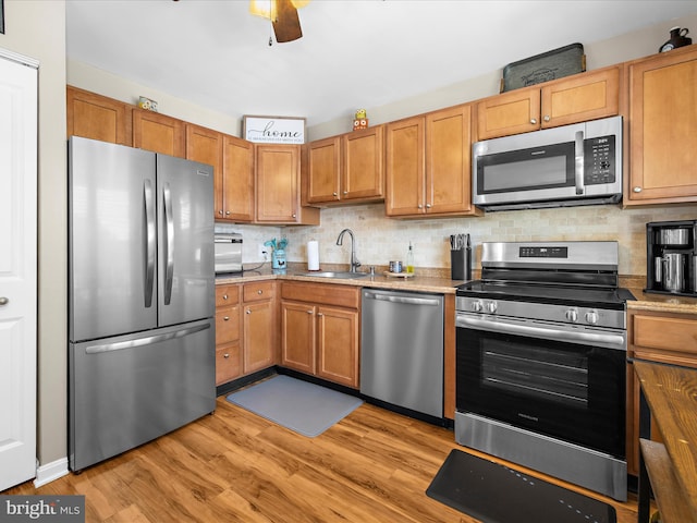 2524 Vineyard Ln, Crofton, MD 21114 - kitchen featuring stainless steel appliances, a sink, light wood-style flooring, and tasteful backsplash
