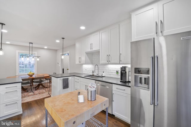 4831 Alton Pl NW, Washington, DC 20016 - kitchen featuring stainless steel appliances, a sink, dark wood-style flooring, dark countertops, and recessed lighting