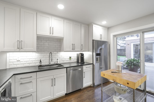 4831 Alton Pl NW, Washington, DC 20016 - kitchen featuring stainless steel appliances, a sink, dark wood-style floors, white cabinetry, and tasteful backsplash