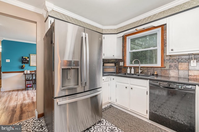 kitchen with stainless steel fridge, black dishwasher, a sink, dark countertops, and white cabinetry