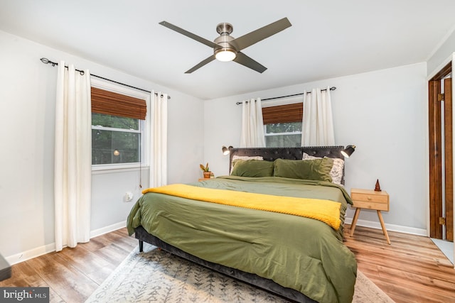 bedroom with wood finished floors, baseboards, and ceiling fan