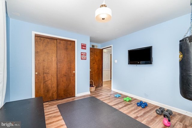 workout room with wood finished floors and baseboards