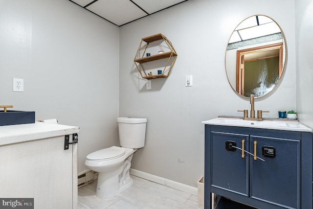 bathroom with vanity, toilet, and baseboards
