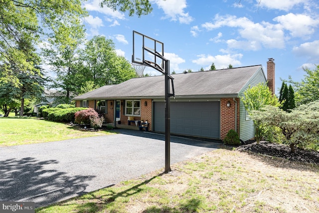 ranch-style house with brick siding, a garage, a front yard, asphalt driveway, and a chimney