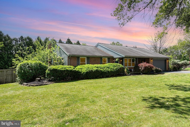ranch-style house featuring an attached garage, brick siding, and asphalt driveway
