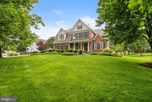 21381 Chickacoan Trail Dr, Broadlands, VA 20148 - view of front facade with brick siding, a front lawn, and covered porch