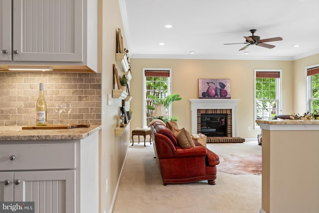 21381 Chickacoan Trail Dr, Broadlands, VA 20148 - living area with crown molding, a fireplace, light colored carpet, plenty of natural light, and a ceiling fan