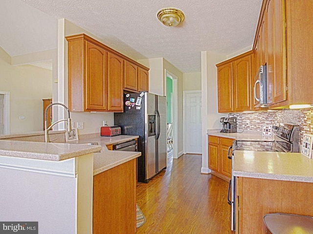 551 N Buckton Rd, Middletown, VA 22645 - kitchen with stainless steel appliances, a peninsula, light wood-style floors, tasteful backsplash, and light countertops