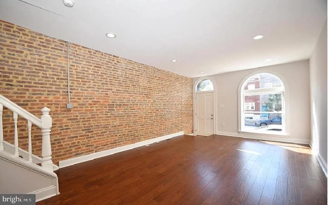 217 S E Ave S, Baltimore, MD 21224 - unfurnished living room featuring brick wall, baseboards, stairs, wood-type flooring, and recessed lighting
