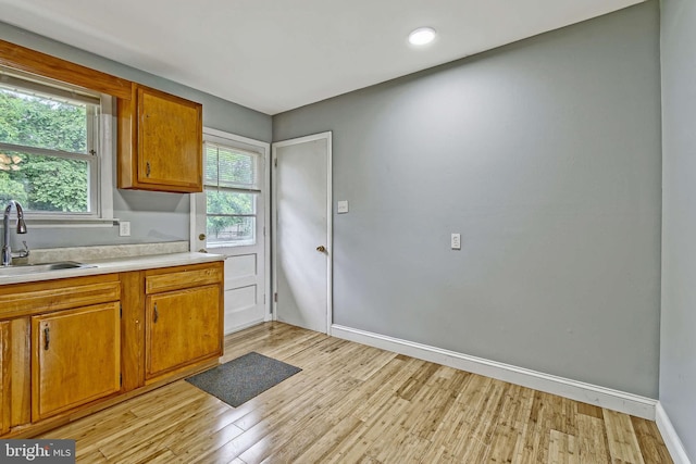3176 S Hance Bridge Rd, Vineland, NJ 08361 - kitchen with a sink, light countertops, light wood-type flooring, and brown cabinets