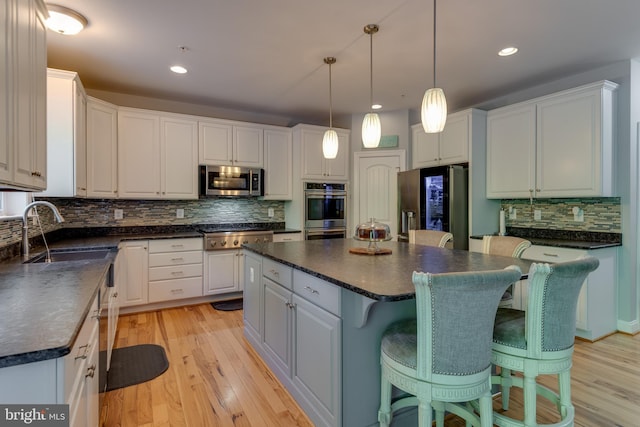 3565 Sauvignon Ln, Chesapeake Beach, MD 20732 - kitchen with dark countertops, appliances with stainless steel finishes, a center island, tasteful backsplash, and white cabinets