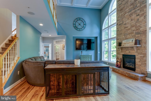 3565 Sauvignon Ln, Chesapeake Beach, MD 20732 - living area featuring light wood-type flooring, healthy amount of natural light, a stone fireplace, and a towering ceiling