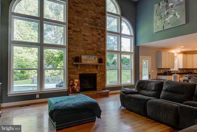 3565 Sauvignon Ln, Chesapeake Beach, MD 20732 - living room featuring a high ceiling, healthy amount of natural light, light wood-style floors, and a fireplace