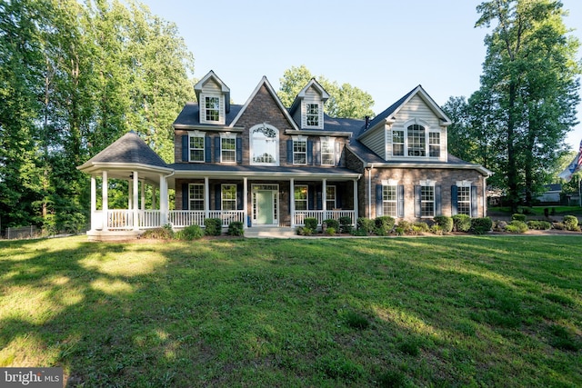 3565 Sauvignon Ln, Chesapeake Beach, MD 20732 - colonial-style house with a porch, a front yard, and stone siding