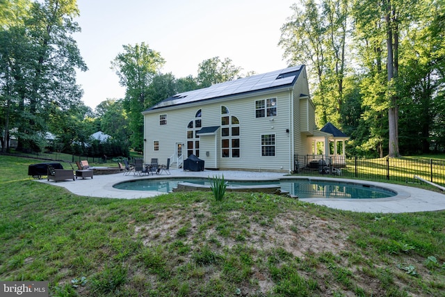 3565 Sauvignon Ln, Chesapeake Beach, MD 20732 - back of property featuring roof mounted solar panels, a patio area, and a wooden deck