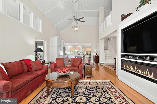 30558 Luff Ln Unit C-14, Ocean View, DE 19970 - living area with a ceiling fan, light wood finished floors, high vaulted ceiling, stairs, and a glass covered fireplace