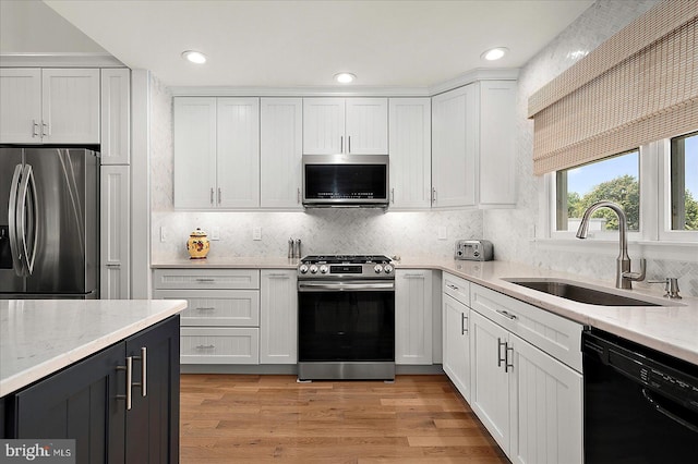 30558 Luff Ln Unit C-14, Ocean View, DE 19970 - kitchen featuring stainless steel appliances, a sink, light stone counters, white cabinetry, and decorative backsplash