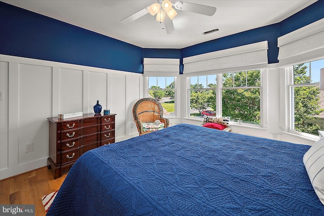 30558 Luff Ln Unit C-14, Ocean View, DE 19970 - bedroom featuring a decorative wall, wood finished floors, a wainscoted wall, and a ceiling fan