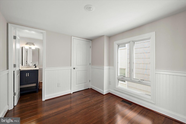 3 129th St Unit 7, Ocean City, MD 21842 - unfurnished bedroom featuring a wainscoted wall, dark wood-style flooring, and a closet