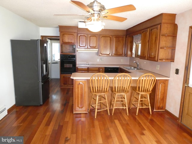 2358 Atco Ave, Atco, NJ 08004 - kitchen with black appliances, a sink, brown cabinetry, under cabinet range hood, and light countertops