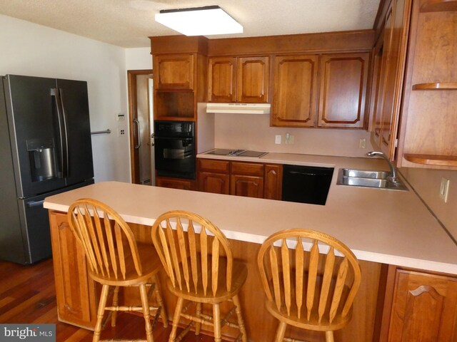 2358 Atco Ave, Atco, NJ 08004 - kitchen with black appliances, a sink, a peninsula, brown cabinetry, and light countertops