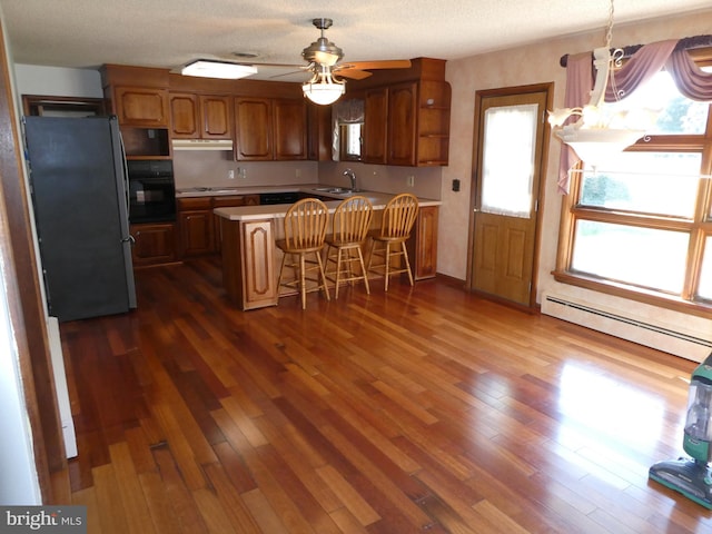 2358 Atco Ave, Atco, NJ 08004 - kitchen with black appliances, baseboard heating, a sink, a peninsula, and light countertops