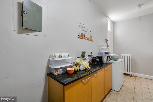 4825 3rd St NW, Washington, DC 20011 - kitchen with radiator, electric panel, dark countertops, and light tile patterned floors