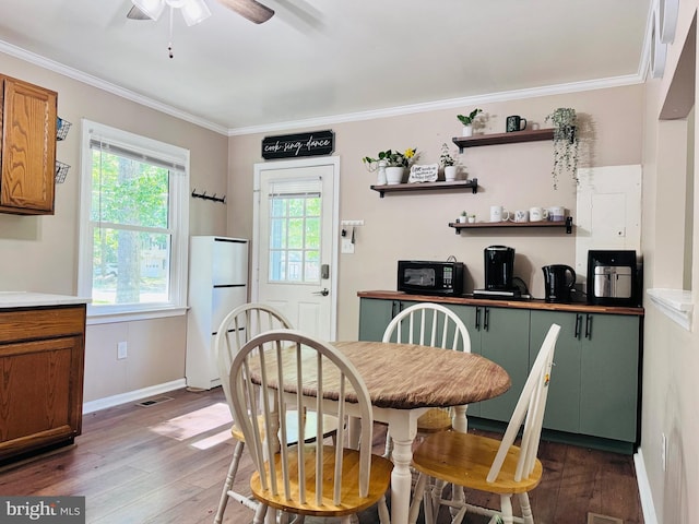 608 Tacketts Mill Rd, Stafford, VA 22556 - dining room with dark wood-style floors, ceiling fan, crown molding, and baseboards