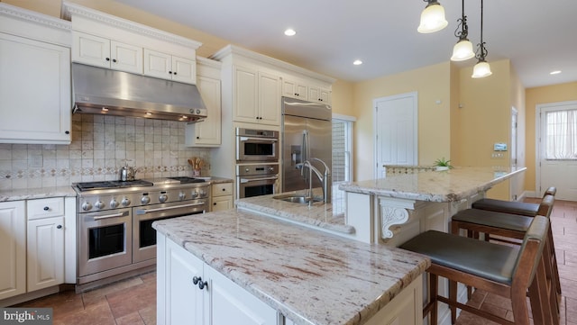 2799 Manion Way, Doylestown, PA 18902 - kitchen with high quality appliances, under cabinet range hood, a center island with sink, decorative backsplash, and recessed lighting