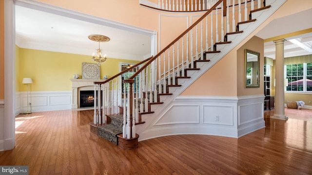 2799 Manion Way, Doylestown, PA 18902 - stairway with hardwood / wood-style flooring, a glass covered fireplace, a decorative wall, a wainscoted wall, and crown molding