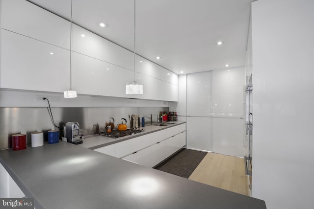 3927 Georgetown Ct NW, Washington, DC 20007 - kitchen with modern cabinets, white cabinetry, stainless steel gas stovetop, wood finished floors, and recessed lighting