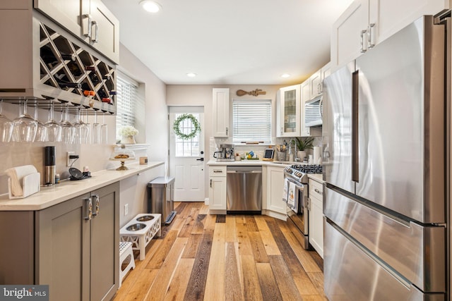 2305 S Croskey St, Philadelphia, PA 19145 - kitchen with appliances with stainless steel finishes, light wood-type flooring, recessed lighting, light countertops, and glass insert cabinets