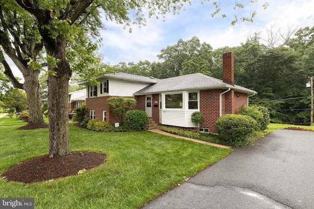 522 Goucher Blvd, Baltimore, MD 21286 - tri-level home featuring brick siding, a chimney, a front yard, and roof with shingles
