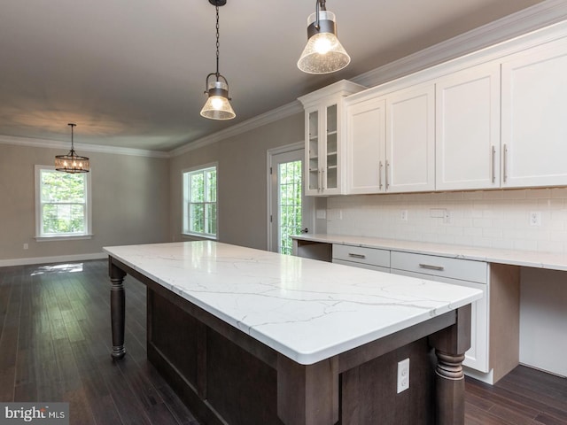 kitchen with white cabinetry, a kitchen island, ornamental molding, backsplash, and dark wood-style flooring
