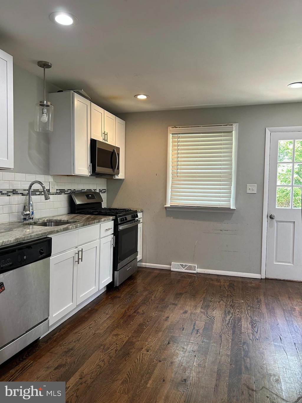 1258 W Cornell St, Vineland, NJ 08360 - kitchen with stainless steel appliances, dark wood finished floors, white cabinets, backsplash, and recessed lighting