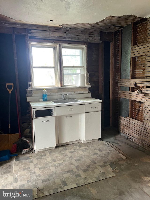 303 Johnson Ave, Upper Chichester, PA 19061 - kitchen featuring a sink, light countertops, and white cabinetry