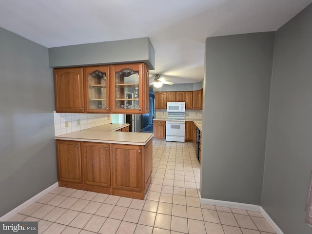 616 Sylvan Pl, Harrisburg, PA 17109 - kitchen featuring white appliances, brown cabinets, tasteful backsplash, light tile patterned floors, and a peninsula